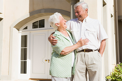 Image: older couple laughing together in front of house