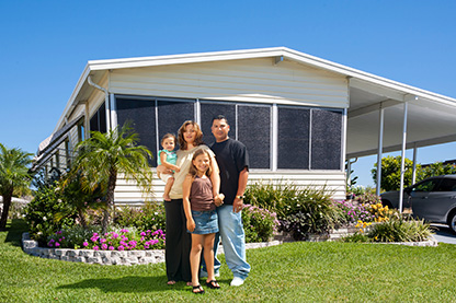 Image: Young family in front of a mobile home smiling