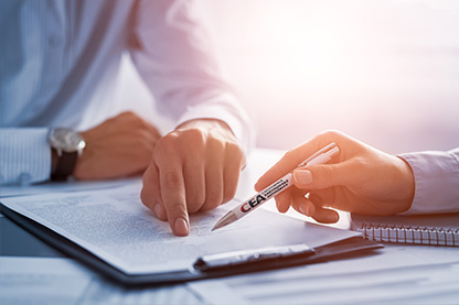 hand of an insurance agent holding a pen pointing at a CEA p
